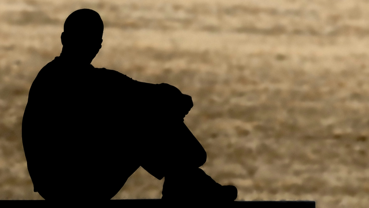 Veteran silhouette sitting on ground and reflecting